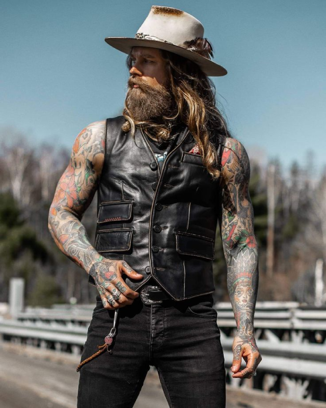 Bearded rider wearing traditional black leather biker vest with front pockets – Biker Vest US